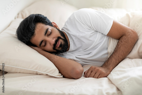 Portrait Of Young Handsome Indian Guy Sleeping In Comfortable Bed At Home