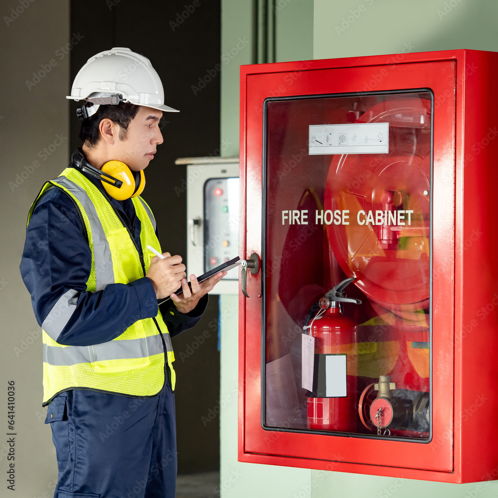 Photography Building inspector man using digital tablet checking fire hose cabinet