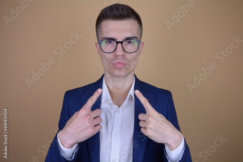 Elegantly Overconfident Man Pointing at Himself with a Smirk on Isolated Background photo
