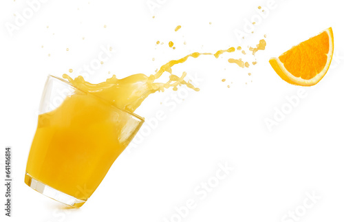 Tilted drinking glass with orange juice spilling out and a flying orange slice isolated on white background. Real studio photo.