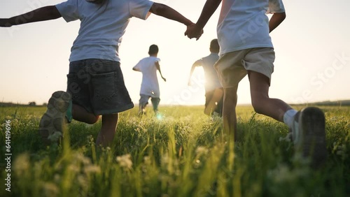 happy family. Child run at sunset in summer. group of kid team run together on green field. Child play have fun together in team outdoors in park. Summer recreation of kid in park on grass. Kid dream