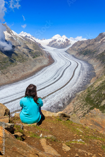 Young woman enjoying the stunning view of the Great Aletsch Glacier in Valais canton, Switzerland