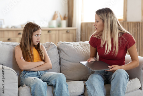 Strict mother scolding preteen daughter for long laptop use