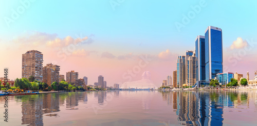Obraz na płótnie Cairo downtown reflecting in the waters of Nile river, beautiful sunset scenery, Egypt w salonie