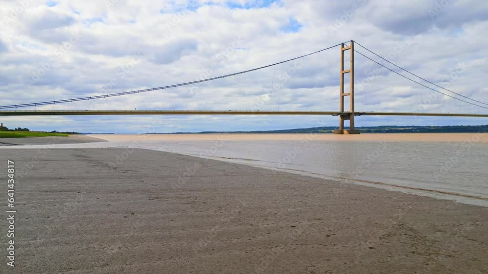 Aerial drone view of Humber Bridge, 12th largest suspension span, gracefully crossing River Humber, connecting Lincolnshire to Humberside with traffic. Aerial drone view of Humber Bridge, 12th largest suspension span, gracefully crossing River Humber, connecting Lincolnshire to Humberside with traffic.