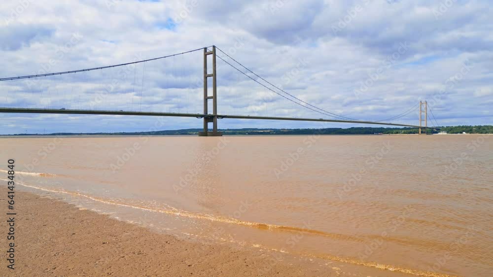 Aerial drone view of Humber Bridge, 12th largest suspension span, gracefully crossing River Humber, connecting Lincolnshire to Humberside with traffic. Aerial drone view of Humber Bridge, 12th largest suspension span, gracefully crossing River Humber, connecting Lincolnshire to Humberside with traffic.