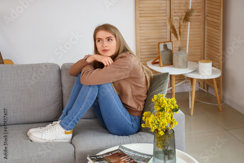 Thoughtful young woman sitt...