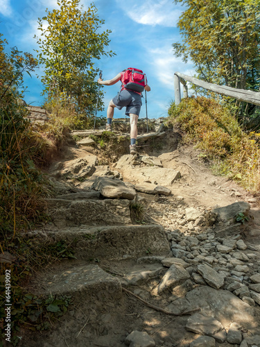 Hiker climbing up steep tourist trail to Wielka Racza, Beskid Zywiecki, Poland photo