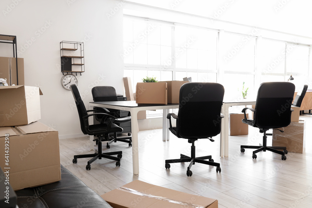 Interior of light office with cardboard boxes on moving day Interior of light office with cardboard boxes on moving day