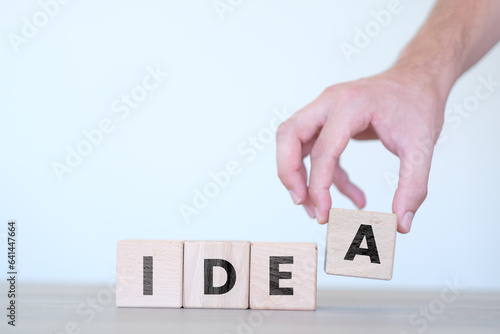 Man ordering idea word on wooden block cubes, strategy or creativity idea, wooden block cubes with idea text on it, wood blocks on white background, banner idea