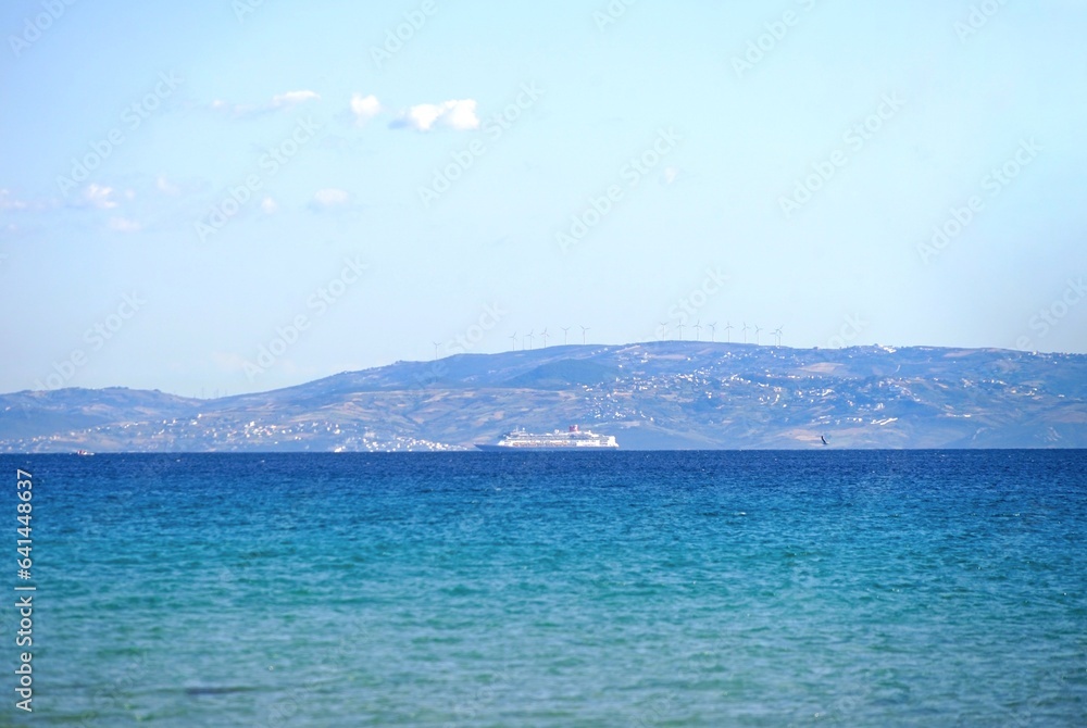 small cruise ship passing through the Strait of Gibraltar and entering the Atlantic Ocean, seen from a viewpoint in Andalusia, province of Cádiz, Spain