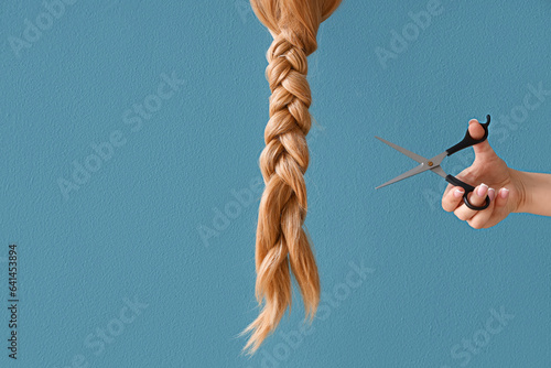 Female hand with scissors a...