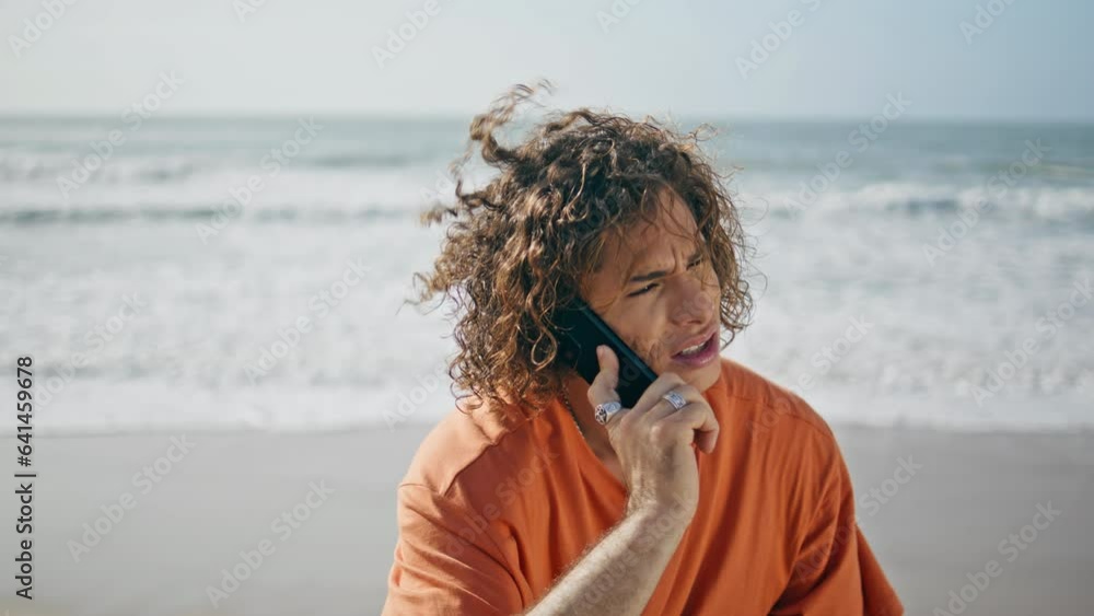 Man talking smartphone beach close up. Worried guy calling mobile phone on shore Man talking smartphone beach close up. Worried guy calling mobile phone on shore