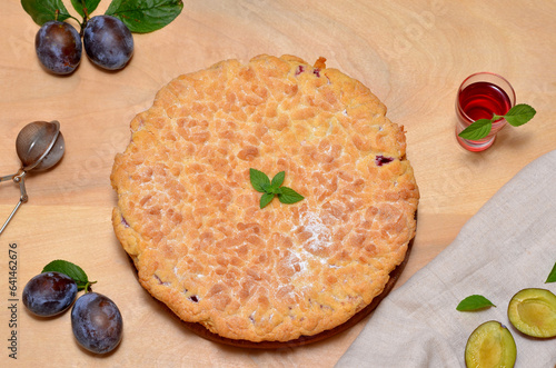 still life with a freshly baked pie, plums and brandy photo