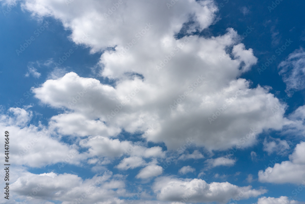 Fluffy White Clouds With Hints of Grey Against Bright Blue Sky Fluffy White Clouds With Hints of Grey Against Bright Blue Sky