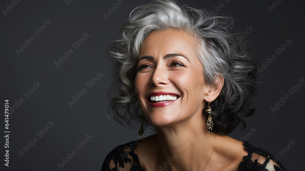 happy woman smiling while standing on gray background
