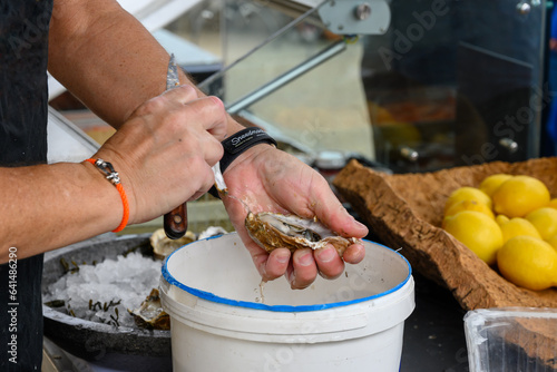 Shucking of Fresh french Gillardeau oysters molluscs on oysters festival in Normandy, france, ready to eat