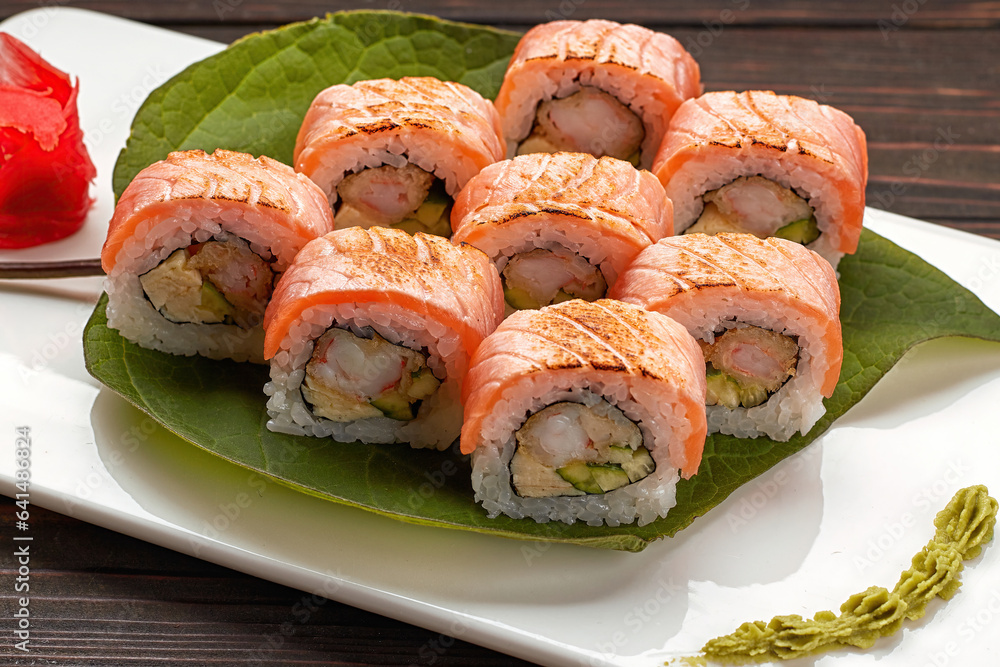 Delicious sushi rolls with wasabi and ginger with chopsticks. Close up Delicious sushi rolls with wasabi and ginger with chopsticks. Close up