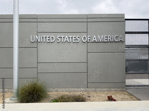 Foto A federal building at the US-Mexico border has a flat, austere concrete wall with steel letters spelling out: United States of America