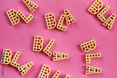 Close-up view of alphabet pasta letters forming words ‘bla’ against pink background   photo