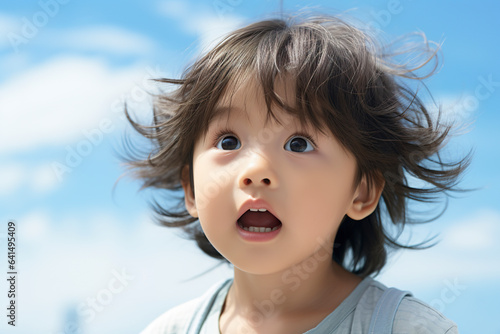Portrait of a little Japanese kid playing in kindergarten. Closeup of little boy outdoors radiating the joy of play in a moving image of innocence and exuberance.