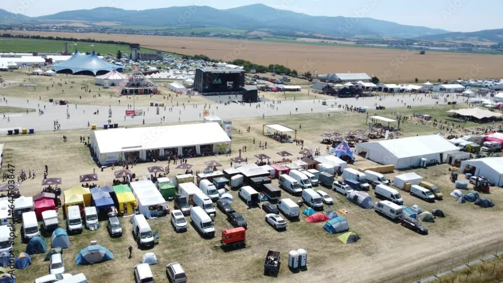 Pohoda Musical Festival 2023 in Slovakia filled with tents and cars in parking lot aerial shot by drone day Pohoda Musical Festival 2023 in Slovakia filled with tents and cars in parking lot aerial shot by drone day