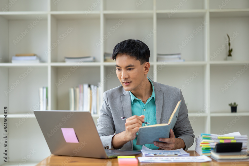 Asian man in corporate office, businessman who owns a startup company sits in office, professional executive runs a company, managing the business to grow and make a profit. Company executives' ideas. Asian man in corporate office, businessman who owns a startup company sits in office, professional executive runs a company, managing the business to grow and make a profit. Company executives' ideas.