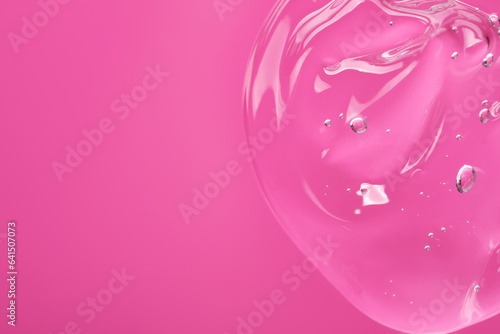 Sample of cleansing gel on pink background, top view with space for text. Cosmetic product