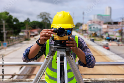 Surveyor engineer wearing safety uniform and helmet with equipment theodolite to measurement positioning on the construction site of the road