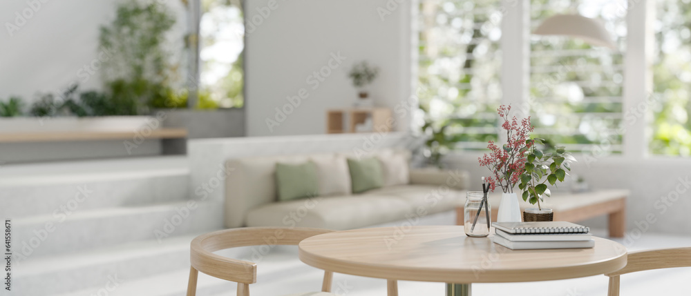 Close-up image of a wooden table with a wooden chair in a modern spacious bright living room.