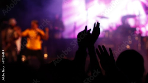 Out of focus video of a concert with the silhouette of people enjoying the night. Concept of people and leisure activities.