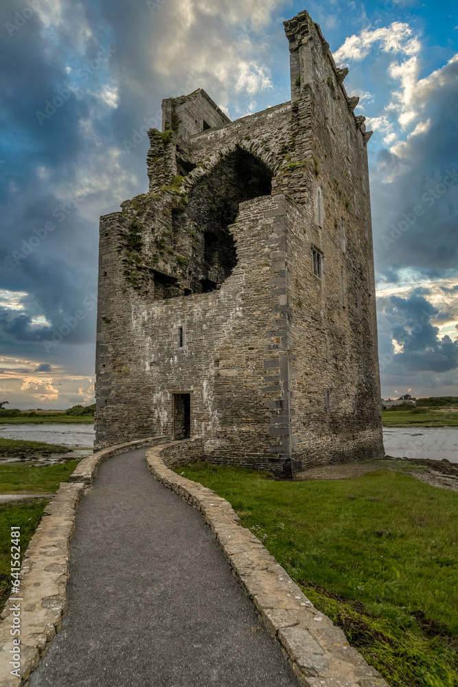 Partially demolished fortified tower house of Carrigafoyle castle in Ireland with dramatic sunset sky background Partially demolished fortified tower house of Carrigafoyle castle in Ireland with dramatic sunset sky background
