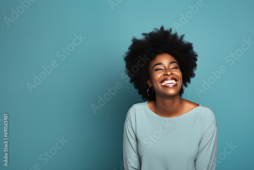 portrait of black woman smiling in a studio, plain colour background