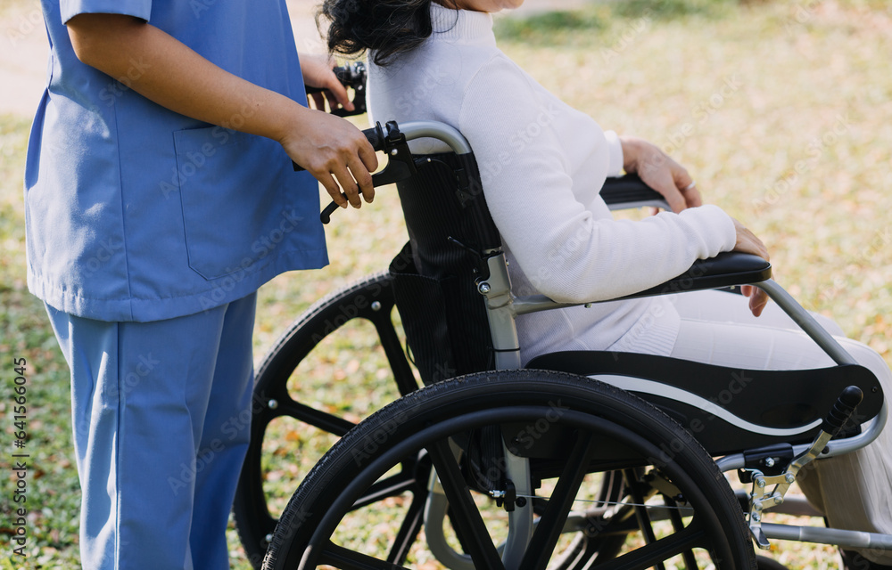 Fototapeta premium Asian young woman nurse at nursing home take care disabled senior man. Caregiver doctor serve physical therapy for older elderly patient to exercise and practice walking on walker or cane at backyard.