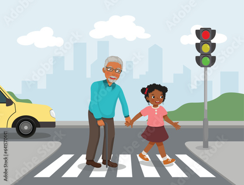 Little African girl help elderly grandfather crossing street at the pedestrian traffic
