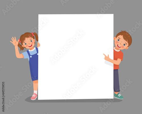 Kids standing behind empty banner peeking and pointing finger over the board waving hand