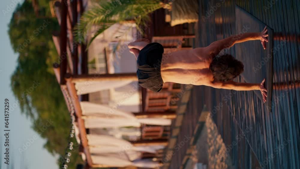 The guy gets to his feet during a yoga class on the beach. Harmony of body and mind The guy gets to his feet during a yoga class on the beach. Harmony of body and mind