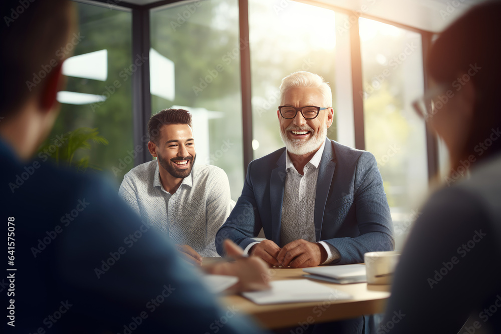 Older Latin company manager leading team meeting in office. Happy diverse professional people group working together in boardroom. Mature business man boss talking to colleagues having discussion.