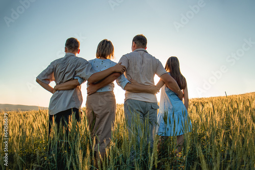 family in the field at sunset  child  mother  father  sunset. happy family  outdoor recreation  mom-dad and children teenagers  silhouette