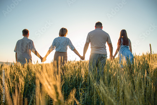family in the field at sunset, child, mother, father, sunset. happy family, outdoor recreation, mom-dad and children teenagers, silhouette