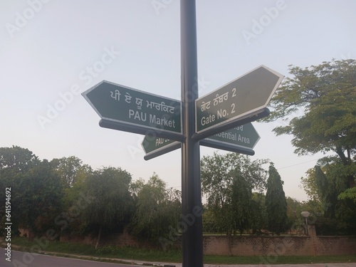 Ludhiana, Punjab - 09 12 2023 : a arrow shaped road signs are installed in english and punjabi language in punjab agricultural university to guide students and other for road map
