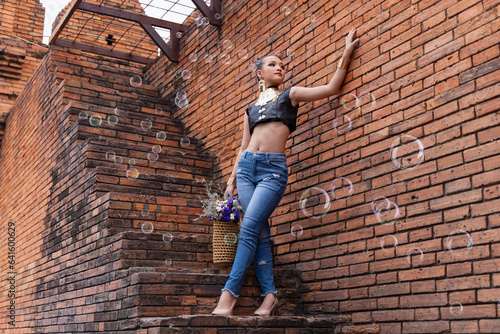 Young Asian woman in craftsmanship dress posting at Thaphae Gate, Landmark of the old city in Chang Mai, Thailand. Welcome to Chiang Mai, Travel ,holiday concept photo