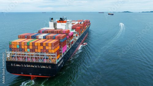 Aerial Stern view of cargo container ship carrying container from custom container depot go to ocean concept freight shipping by ship service on blue sky .Freight Forwarding Service photo