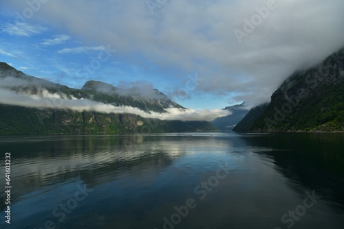 the reflection of low clouds in a mountain lake