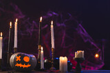 Pumpkins and candles with copy space on purple background