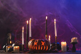 Pumpkins and candles with copy space on purple background