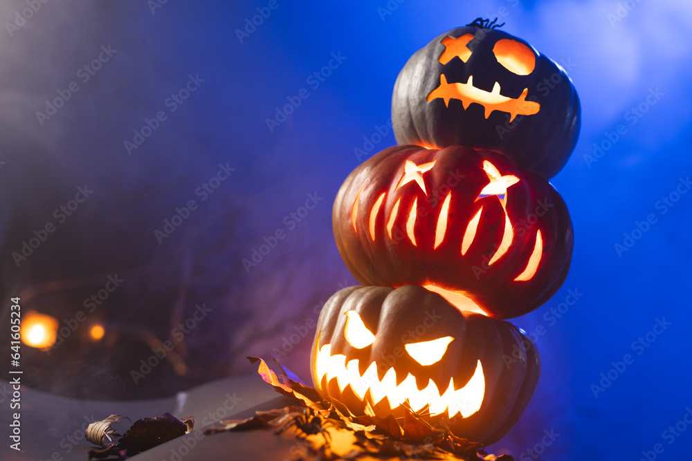 Fototapeta premium Carved pumpkins with copy space on blue background