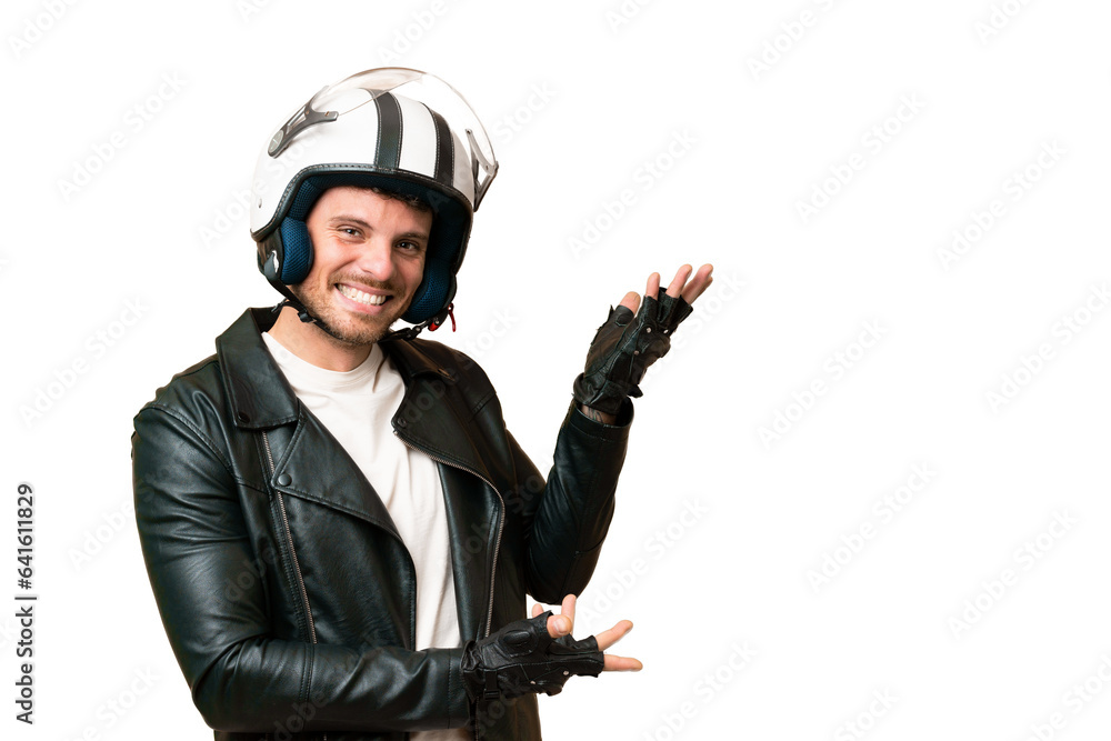 Brazilian man with a motorcycle helmet over isolated chroma key background extending hands to the side for inviting to come Brazilian man with a motorcycle helmet over isolated chroma key background extending hands to the side for inviting to come