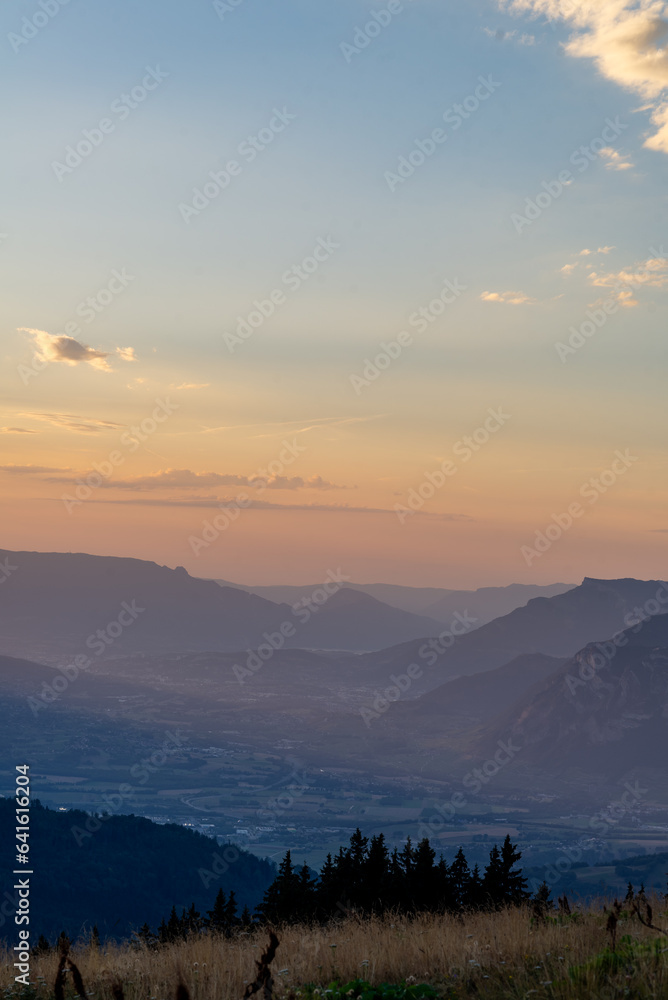 Obraz premium Mountain layers of The Chartreuse mountains and Grésivaudan valley in french alps at sunset.