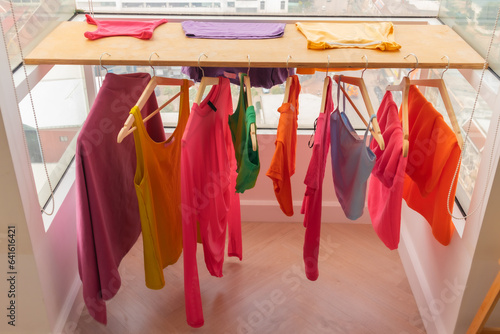 Colorful clothes hanging on the balcony dry in sun at apartment.